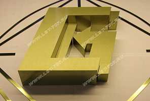 Объемный металлический логотип из шлифованной нержавейки под золото с несколькими уровнями лицевой поверхности.